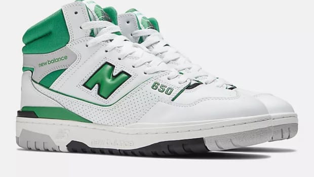 View of white and green New Balance shoes.